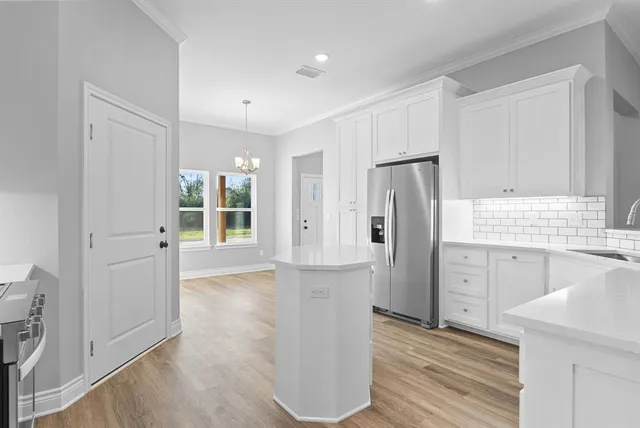 a view of kitchen with a refrigerator cabinets and wooden floor