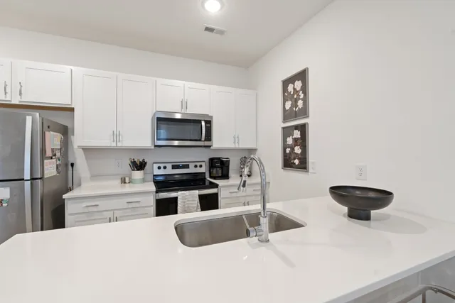 a kitchen with stainless steel appliances a stove a sink and a refrigerator