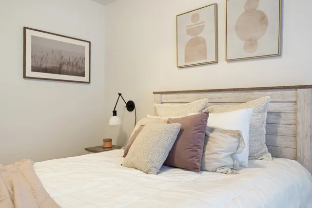 a bedroom with a bed and painting on the wall