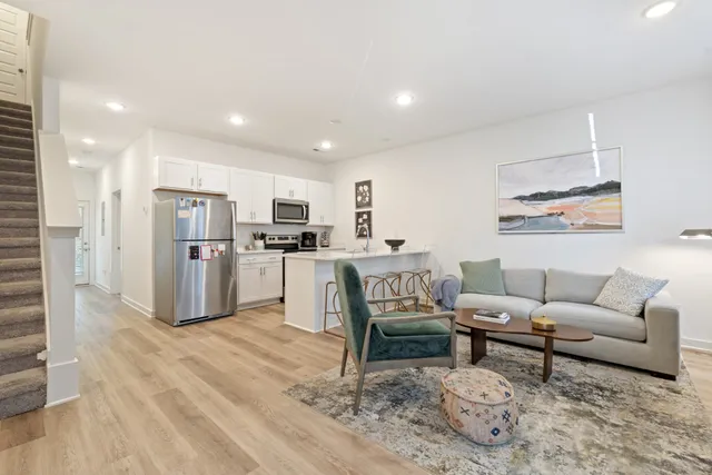a living room with furniture and kitchen view