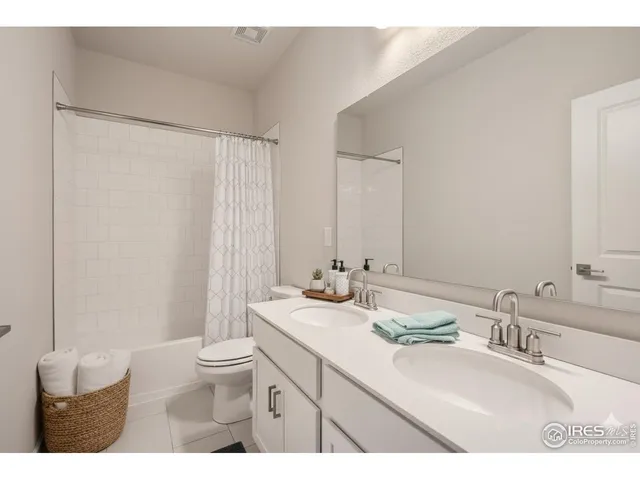 a bathroom with a double vanity sink toilet and a mirror