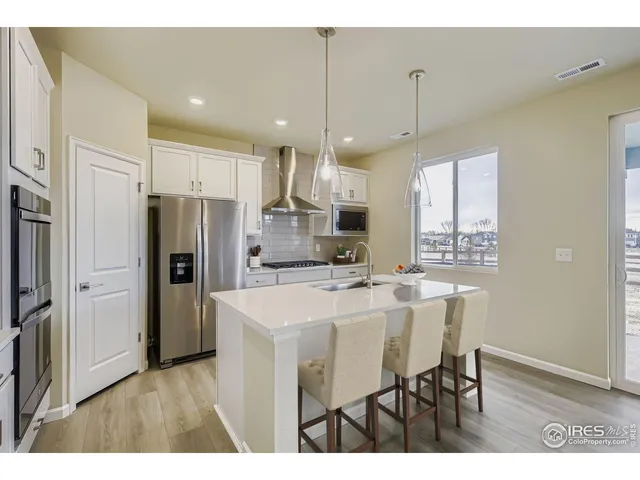 a kitchen with refrigerator cabinets and wooden floor