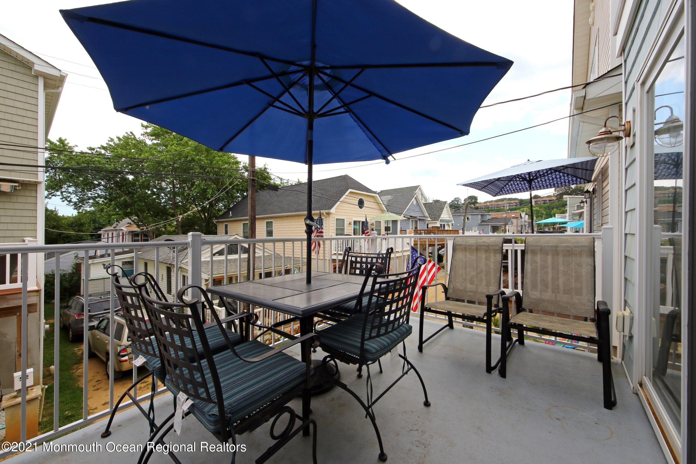 55 Gravelly Point Road Highlands, NJ 07732 - Photo 14 of 34 a view of a roof deck with table and chairs under an umbrella