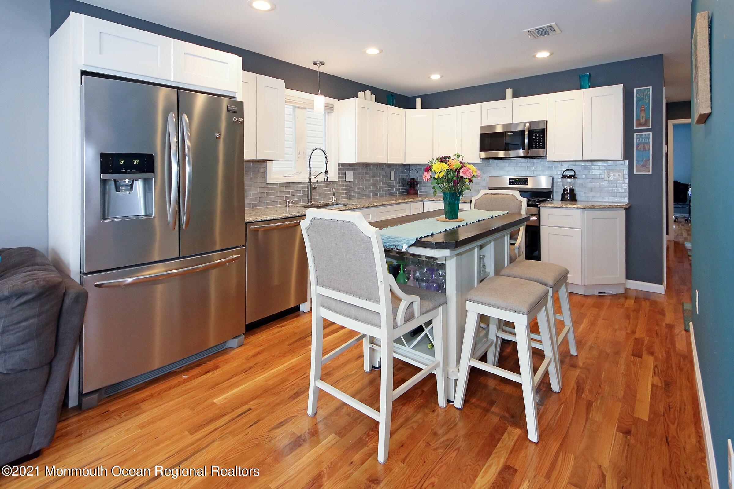 55 Gravelly Point Road Highlands, NJ 07732 - Photo 8 of 34 a kitchen with stainless steel appliances granite countertop a refrigerator microwave and wooden floor