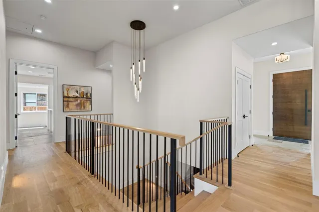 a view of a hallway with wooden floor and staircase