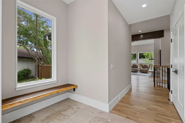 a view of a hallway with wooden floor and windows