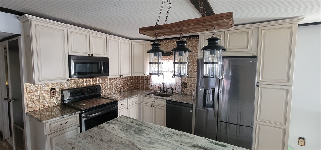 25 Windswept Road Wareham, MA 02571 - Photo 25 of 39 a kitchen with stainless steel appliances kitchen island granite countertop a refrigerator stove and microwave
