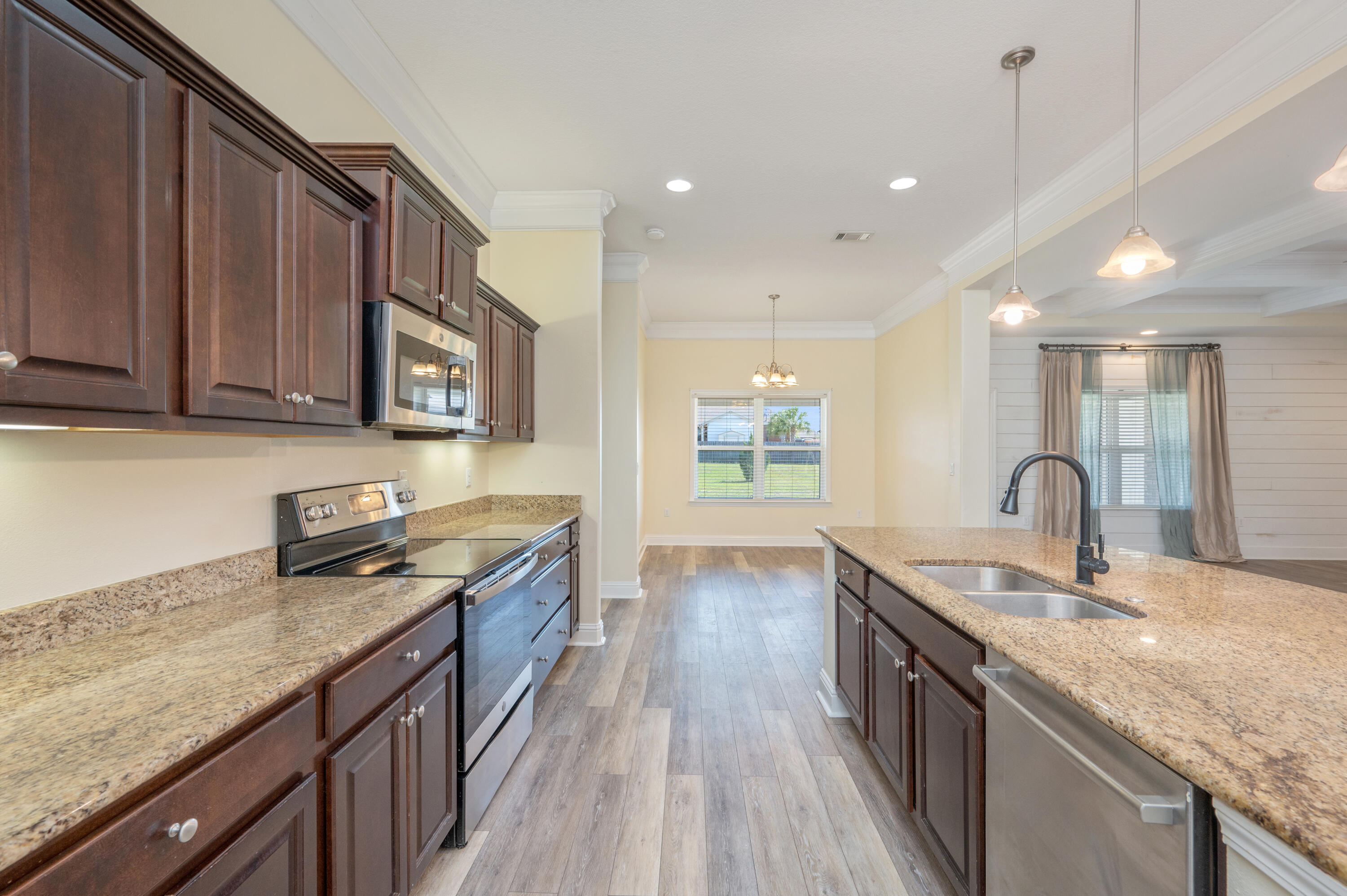 3361 Citrine Circle Crestview, FL 32539 - Photo 12 of 34 a kitchen with granite countertop a sink a stove cabinets and wooden floor