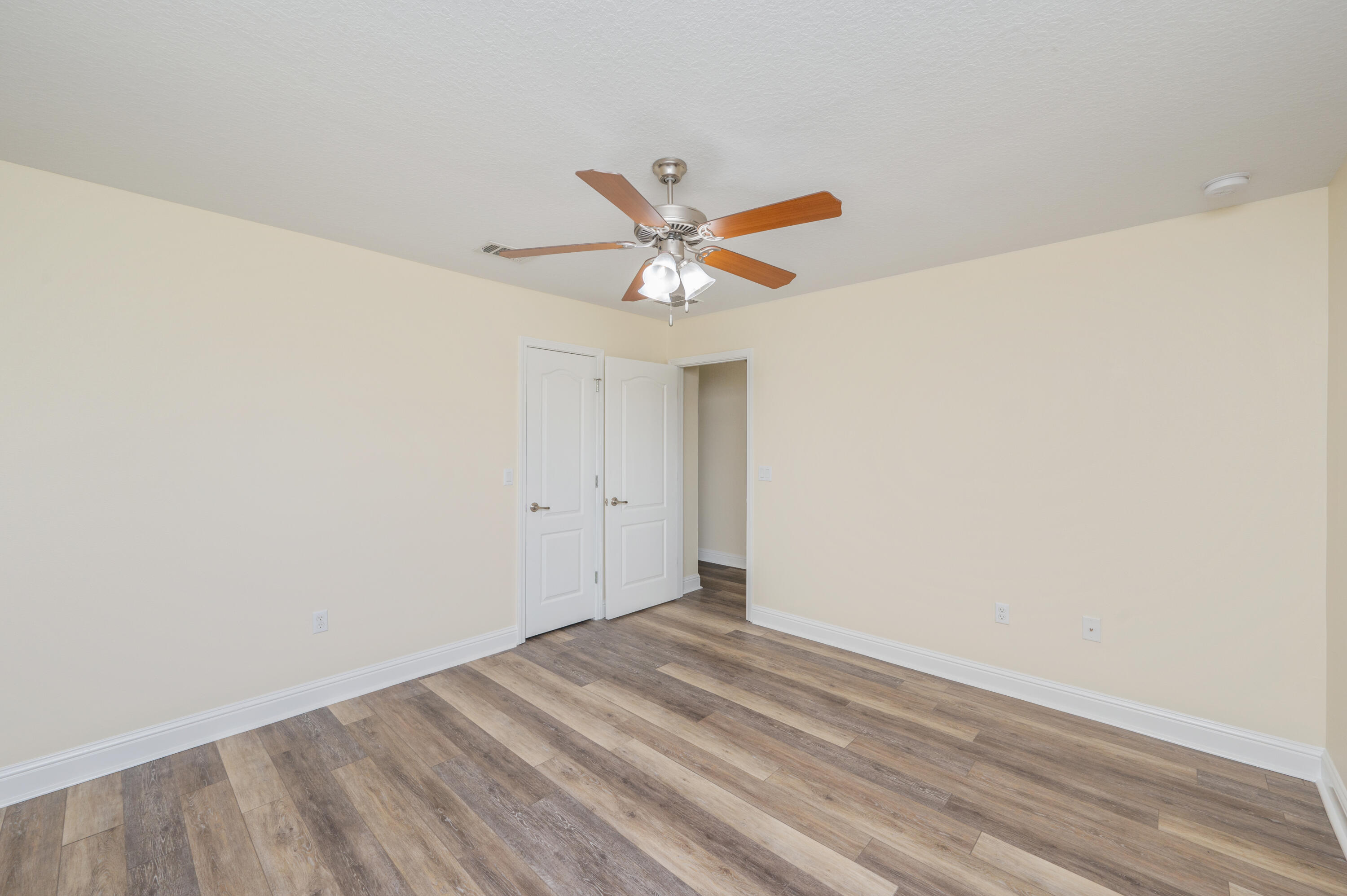3361 Citrine Circle Crestview, FL 32539 - Photo 29 of 34 an empty room with a ceiling fan and wooden floor