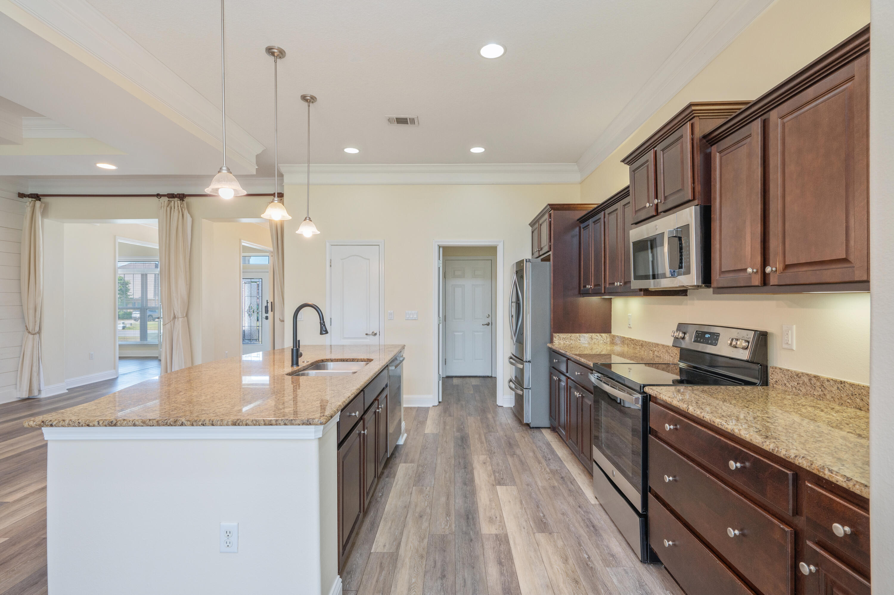 3361 Citrine Circle Crestview, FL 32539 - Photo 9 of 34 a kitchen with stainless steel appliances granite countertop a sink a stove and a wooden floors