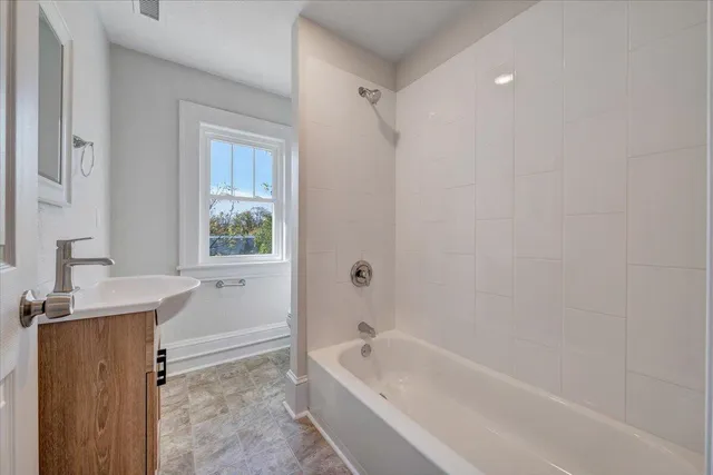 a bathroom with a bathtub a window and a shower