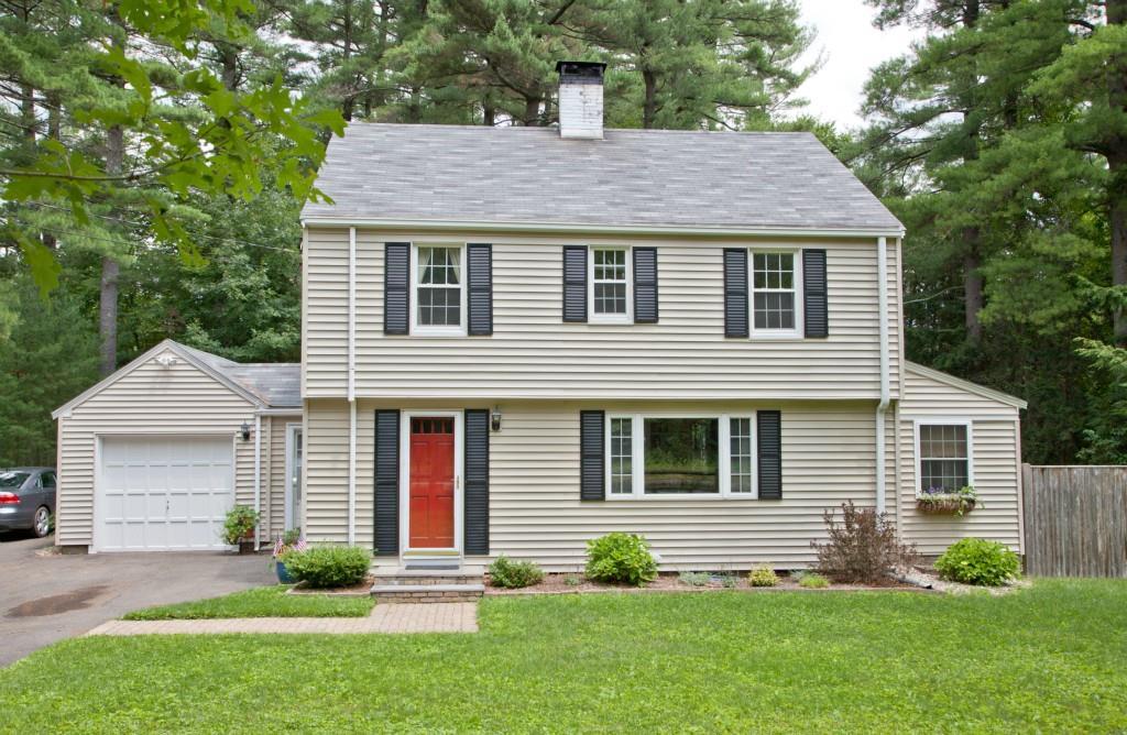 a front view of a house with a yard and green space