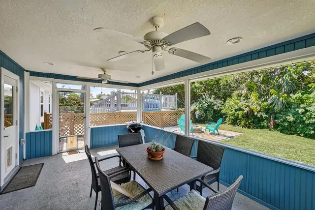 a dining room with furniture large windows and a chandelier