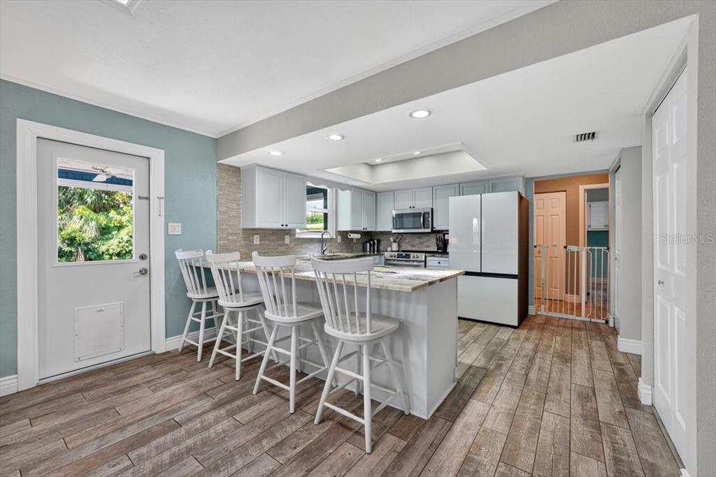 24 Heather Lane Ormond Beach, FL 32174 - Photo 23 of 50 a kitchen with stainless steel appliances a dining table chairs and wooden floor