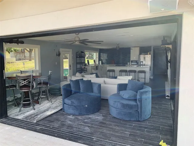 a living room with furniture and a dining table with kitchen view