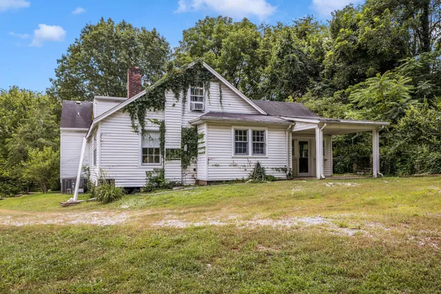 a view of a house with a yard and trees