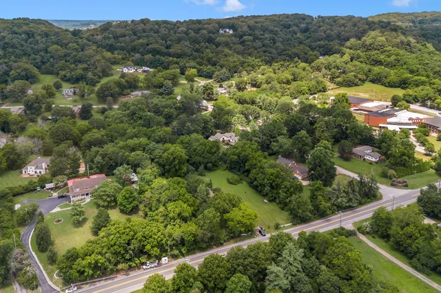 an aerial view of residential houses with outdoor space and trees