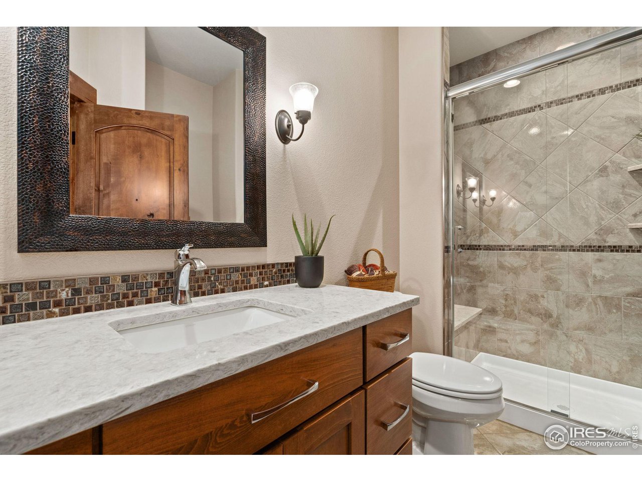 6611 Murano Drive Windsor, CO 80550 - Photo 18 of 35 a bathroom with a sink a toilet a mirror and shower