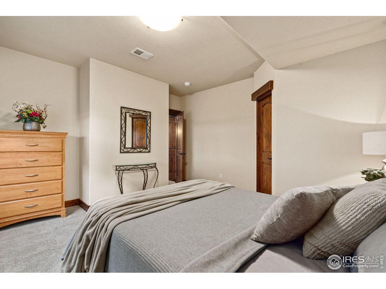 6611 Murano Drive Windsor, CO 80550 - Photo 19 of 35 a bedroom with a bed and dresser