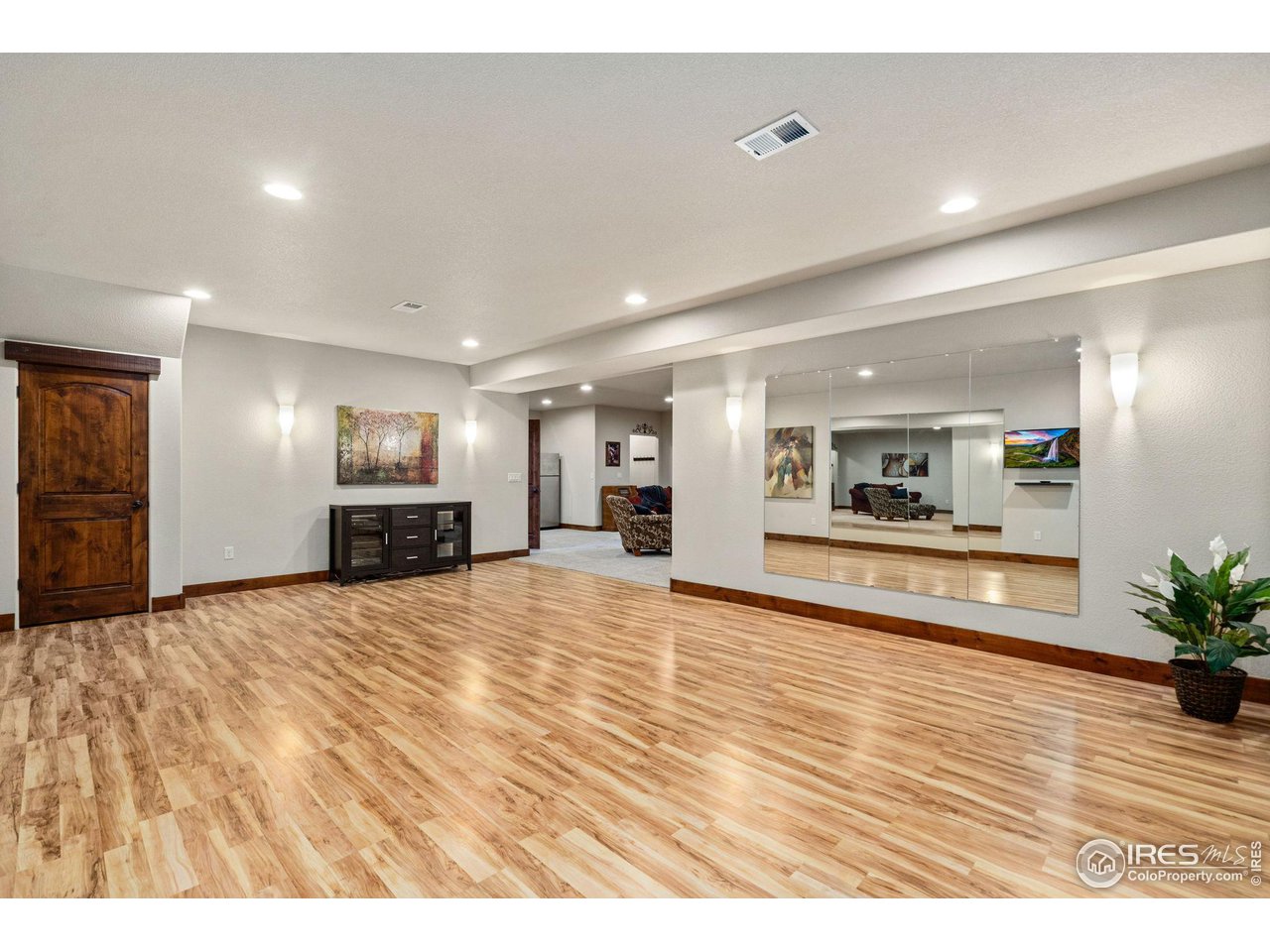 6611 Murano Drive Windsor, CO 80550 - Photo 25 of 35 a view of empty room with kitchen view and wooden floor