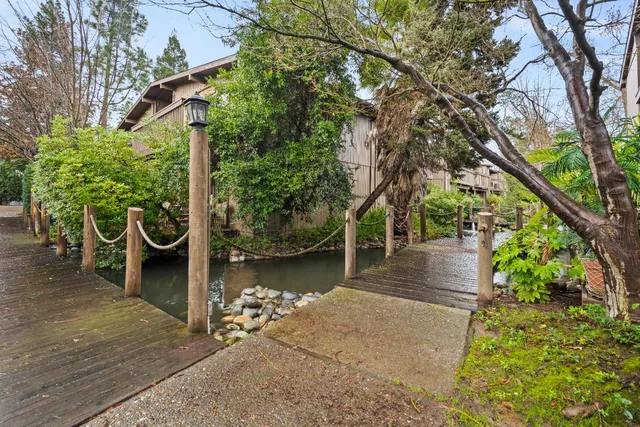 a wooden bench with chairs and trees