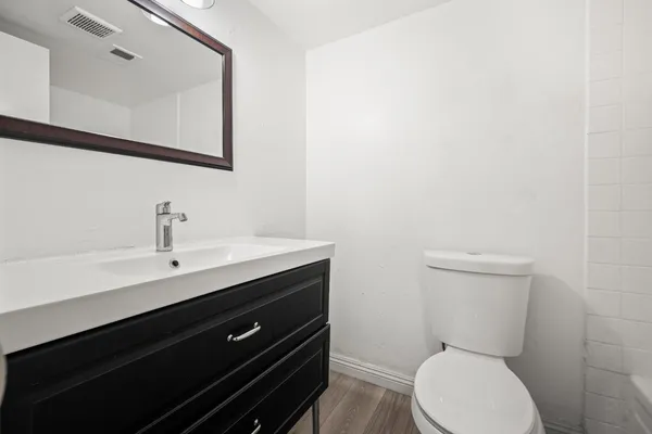 a bathroom with a toilet a sink and mirror