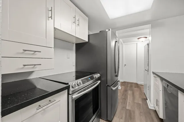 a kitchen with granite countertop a stove and a refrigerator