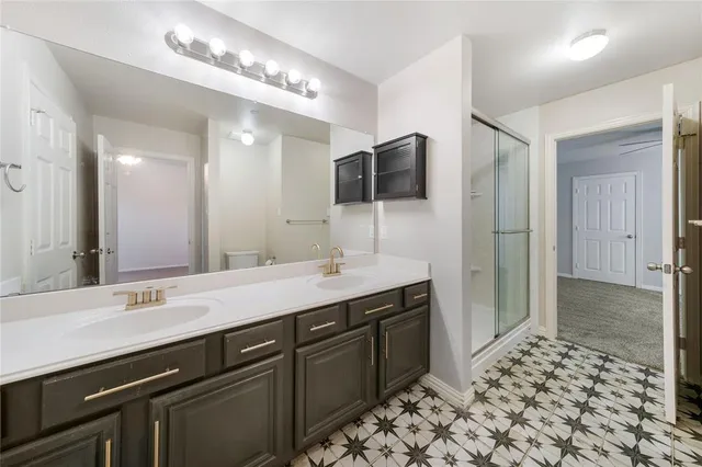 a spacious bathroom with a sink a large mirror and a shower