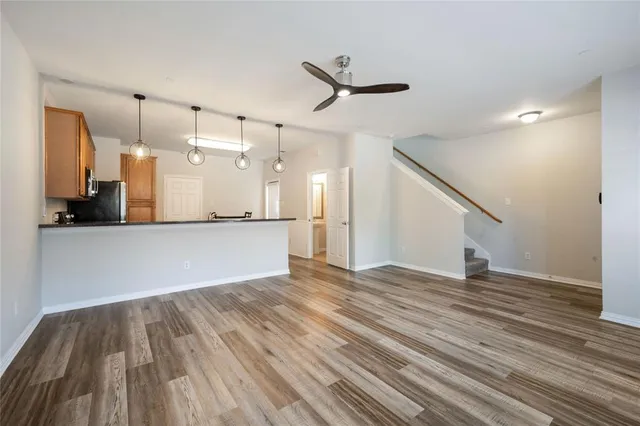 a view of a room with wooden floor and a ceiling fan