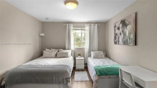 a bedroom with a two bed and a window