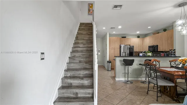 a view of kitchen with stainless steel appliances cabinets and chair