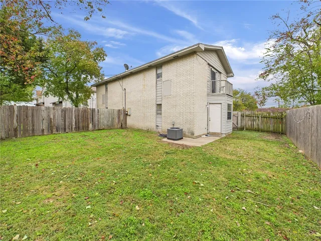 a view of backyard of house with wooden fence
