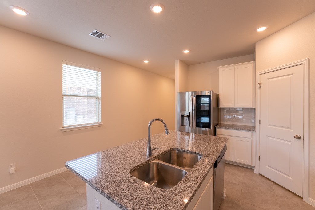 6310 Wolf Pack Drive Pflugerville, TX 78660 - Photo 11 of 34 a kitchen with kitchen island a sink and refrigerator