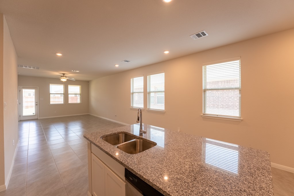 6310 Wolf Pack Drive Pflugerville, TX 78660 - Photo 11 of 33 a kitchen with granite countertop a sink and a window