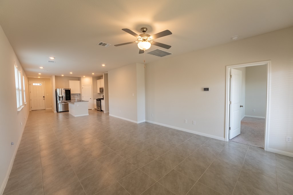 6310 Wolf Pack Drive Pflugerville, TX 78660 - Photo 15 of 34 a view of an empty room and a kitchen