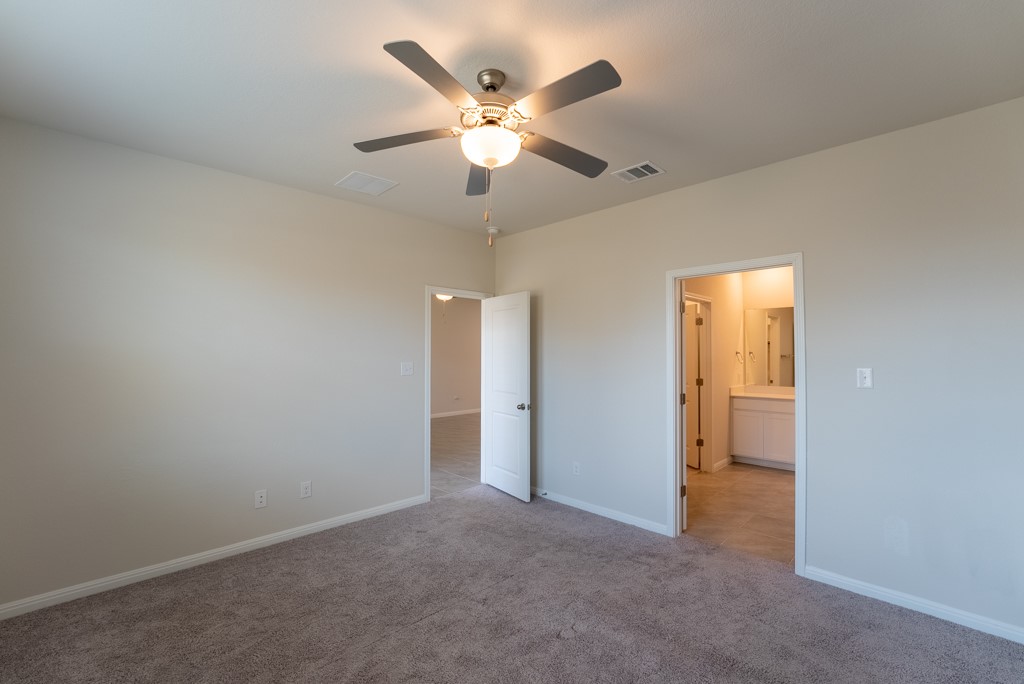6310 Wolf Pack Drive Pflugerville, TX 78660 - Photo 17 of 33 an empty room with closet and ceiling fan