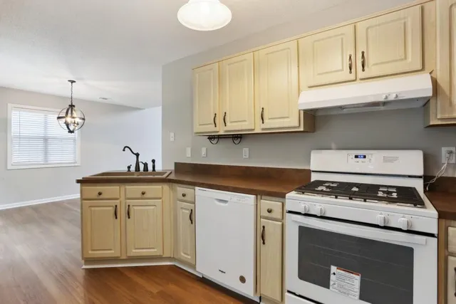 a kitchen with cabinets appliances and a wooden floor