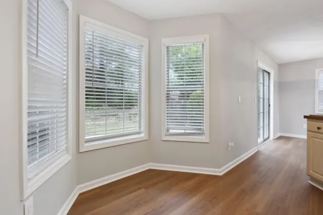 a view of a room with wooden floor and windows