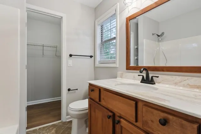 a bathroom with a granite countertop sink toilet and shower