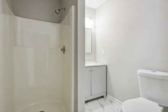 a bathroom with a toilet and a shower