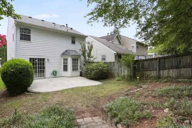 a view of a yard in front of a house with large trees
