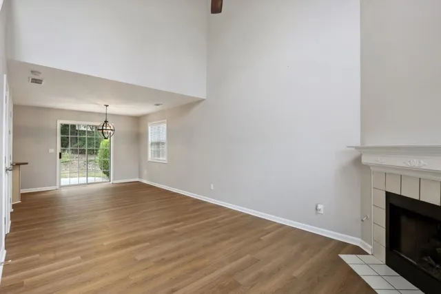 a view of empty room with wooden floor and fireplace