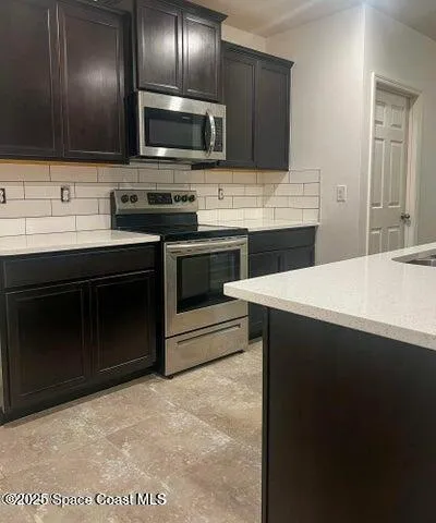 a kitchen with stainless steel appliances a stove a sink and a microwave