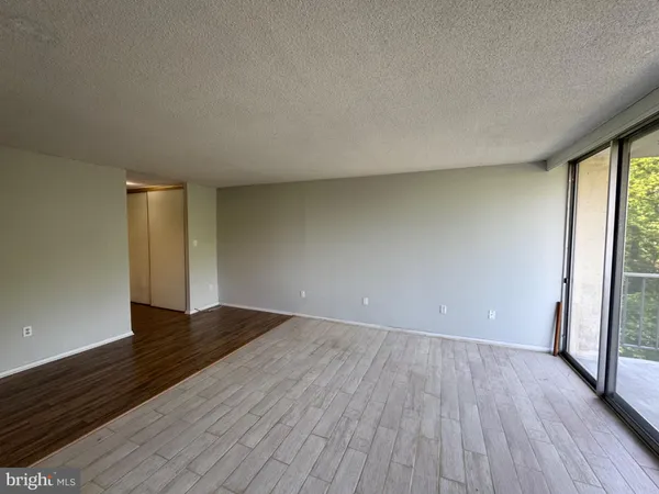 a view of a bedroom with wooden floor and window