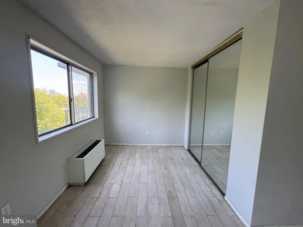 a view of a bedroom with wooden floor and front door