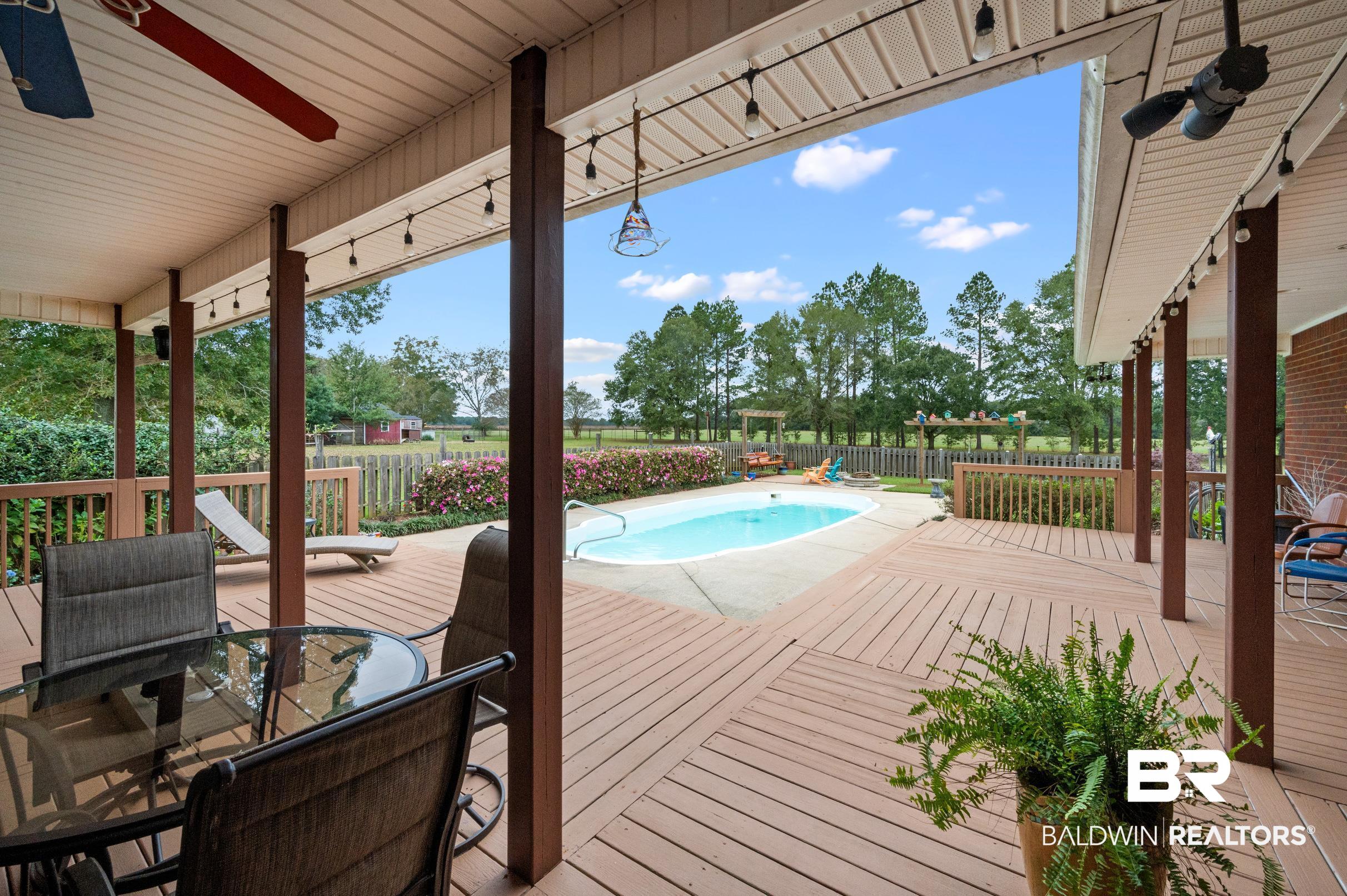 13871 Underwood Road Summerdale, AL 36580 - Photo 20 of 33 Wooden terrace featuring ceiling fan, fire pit and a fenced in pool
