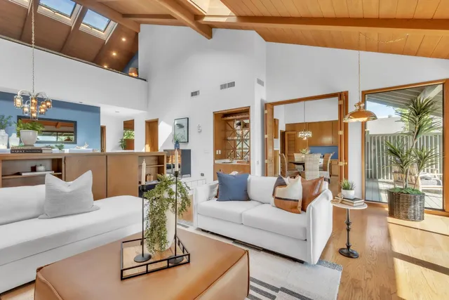 a living room with furniture large window and glass table