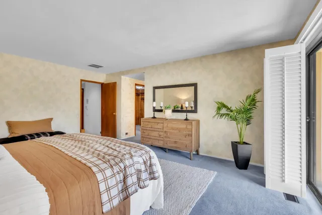 a bedroom with bed and a large window