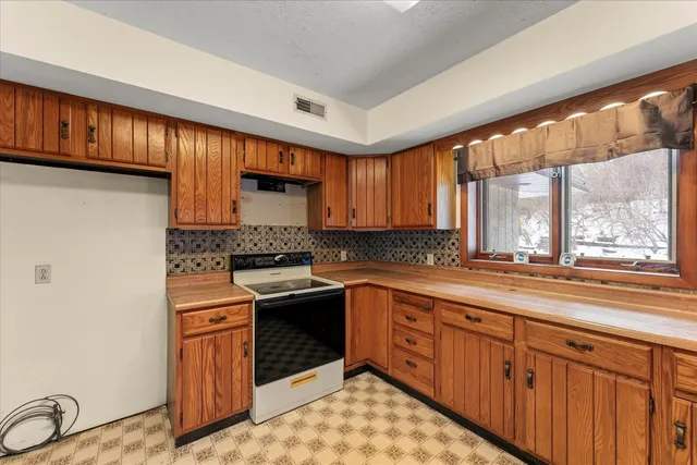 a view of bathroom with a sink mirror and window