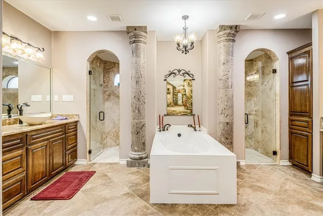 a en suite bathroom with a tub sink and mirror